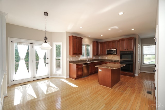 1031 Westchester, Union Twp, OH 45244 - kitchen with appliances with stainless steel finishes, light wood-type flooring, a center island, decorative backsplash, and healthy amount of natural light