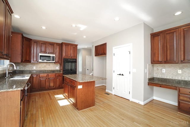 1031 Westchester, Union Twp, OH 45244 - kitchen featuring stainless steel microwave, built in study area, light wood-style floors, tasteful backsplash, and recessed lighting