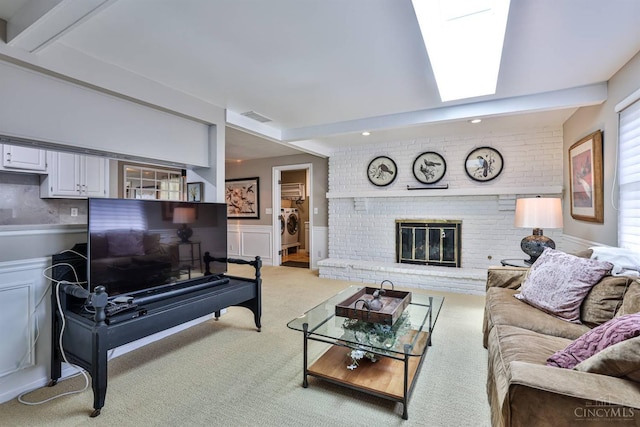 6341 Marshall Rd, Centerville, OH 45459 - living room with washer and dryer, light carpet, a fireplace, beam ceiling, and a wainscoted wall