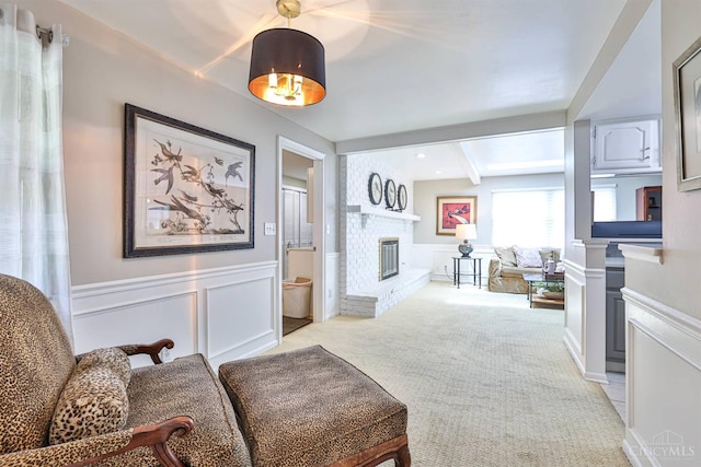 6341 Marshall Rd, Centerville, OH 45459 - living area with a brick fireplace, beam ceiling, a decorative wall, a wainscoted wall, and light carpet