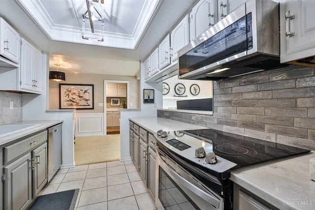 6341 Marshall Rd, Centerville, OH 45459 - kitchen with stainless steel appliances, a tray ceiling, white cabinets, light countertops, and gray cabinets