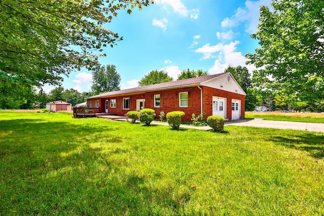 17403 Bloomrose Rd, Sterling Twp, OH 45176 - ranch-style home featuring concrete driveway, brick siding, a front lawn, an outbuilding, and a wooden deck