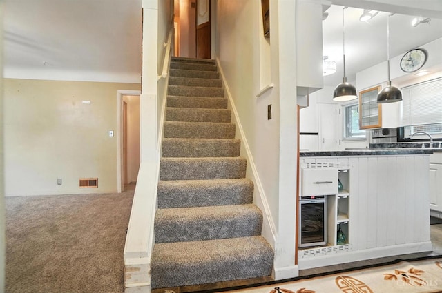 3760 Feldkamp Ave, Green Twp, OH 45211 - stairway featuring wine cooler and carpet flooring