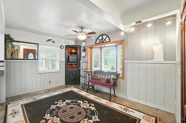 3760 Feldkamp Ave, Green Twp, OH 45211 - living area with plenty of natural light, a ceiling fan, wooden walls, and a wainscoted wall