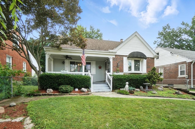 3760 Feldkamp Ave, Green Twp, OH 45211 - view of front facade featuring a porch, ceiling fan, brick siding, and roof with shingles