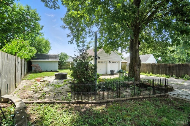 3760 Feldkamp Ave, Green Twp, OH 45211 - fenced backyard with a fire pit, an outbuilding, and a garage