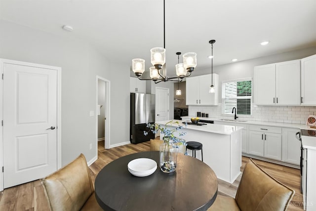 1545 Ruth Ave, Cincinnati, OH 45207 - dining space with a chandelier, light wood-type flooring, and recessed lighting