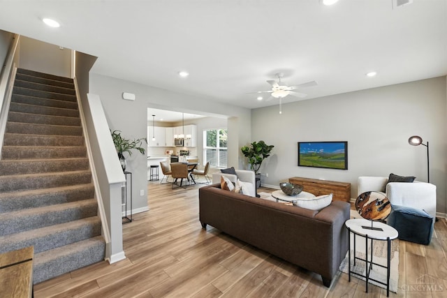 1545 Ruth Ave, Cincinnati, OH 45207 - living room with stairs, light wood-style floors, a ceiling fan, and recessed lighting