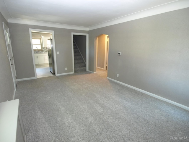3527 Reemelin Rd, Green Twp, OH 45211 - unfurnished room featuring arched walkways, stairs, light carpet, and ornamental molding