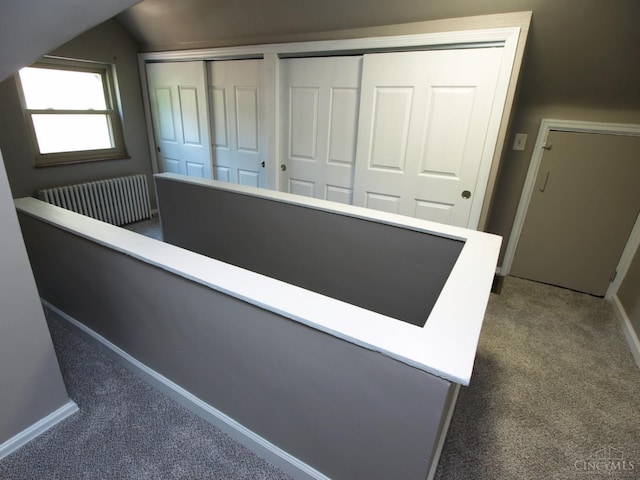 3527 Reemelin Rd, Green Twp, OH 45211 - hallway featuring radiator heating unit, dark colored carpet, lofted ceiling, and an upstairs landing