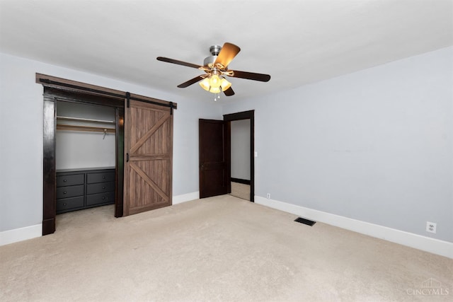 122 Fairview Ave, Washington Twp, OH 45171 - unfurnished bedroom featuring a barn door, carpet, a ceiling fan, and a closet