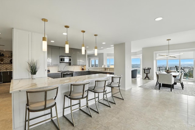 1201 Edgecliff Pl Unit 1083, Cincinnati, OH 45206 - kitchen featuring appliances with stainless steel finishes, a peninsula, gray cabinets, recessed lighting, and a breakfast bar