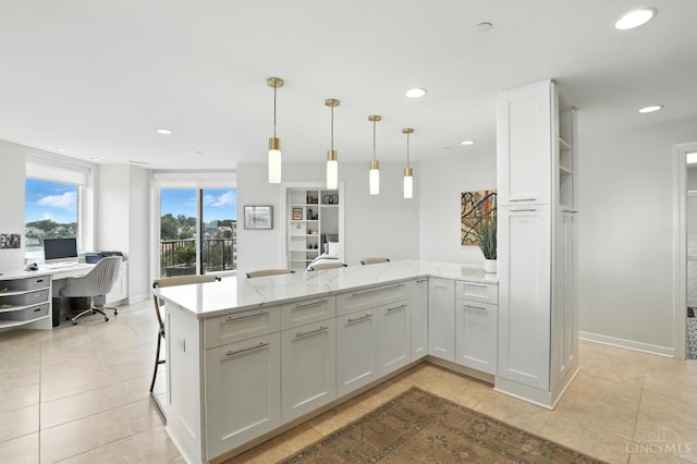 1201 Edgecliff Pl Unit 1083, Cincinnati, OH 45206 - kitchen with a peninsula, an office area, white cabinetry, light stone countertops, and light tile patterned flooring