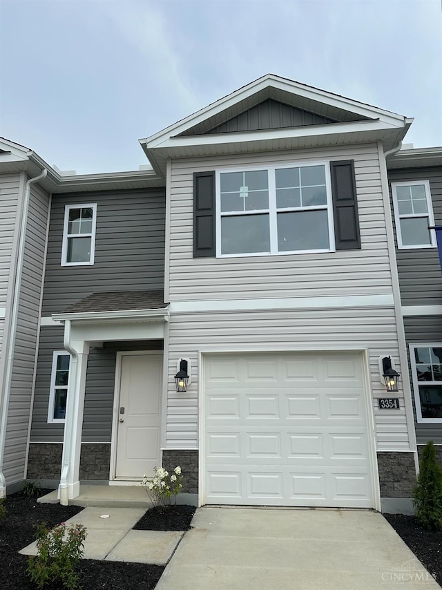 3354 New Year Dr, Colerain Twp, OH 45251 - view of front facade with an attached garage, stone siding, and driveway