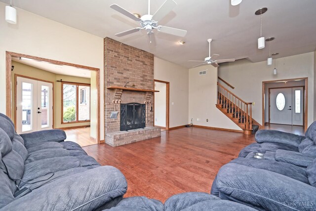 8424 Oak Grove Rd, Georgetown, OH 45121 - living room with a ceiling fan, wood finished floors, stairway, a brick fireplace, and french doors