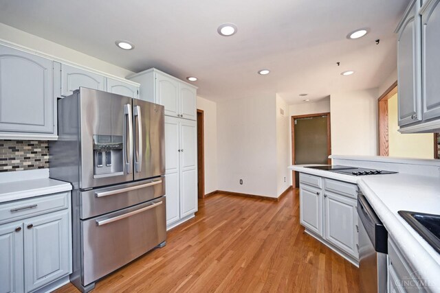 8424 Oak Grove Rd, Georgetown, OH 45121 - kitchen featuring appliances with stainless steel finishes, light wood finished floors, light countertops, tasteful backsplash, and recessed lighting