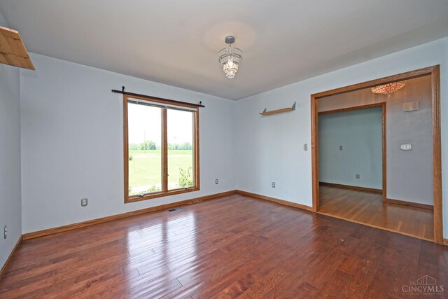 8424 Oak Grove Rd, Georgetown, OH 45121 - spare room featuring wood finished floors and a chandelier
