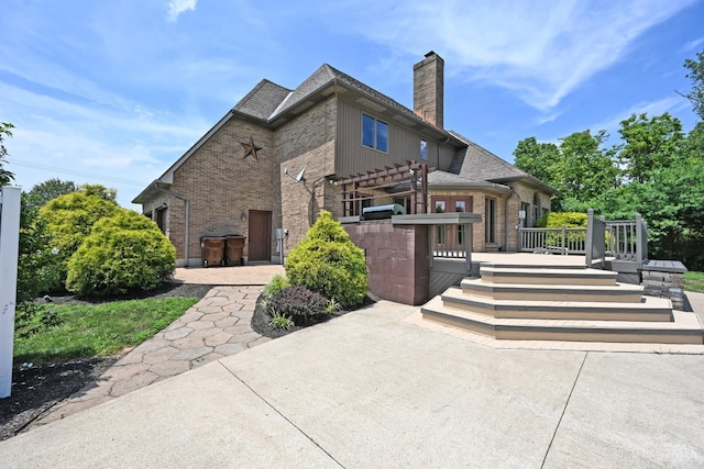8424 Oak Grove Rd, Georgetown, OH 45121 - rear view of house with brick siding, a wooden deck, a chimney, and a patio