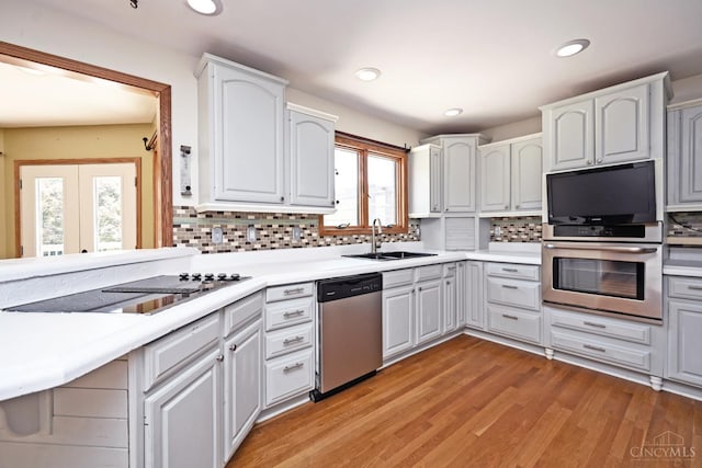 8424 Oak Grove Rd, Georgetown, OH 45121 - kitchen with appliances with stainless steel finishes, decorative backsplash, light countertops, recessed lighting, and light wood-type flooring