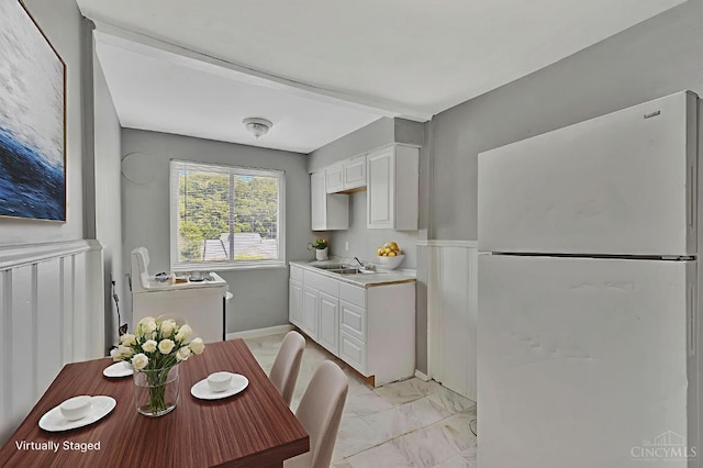 146 Glenridge Pl, Cincinnati, OH 45217 - kitchen featuring freestanding refrigerator, white cabinetry, light countertops, and light marble finish floors