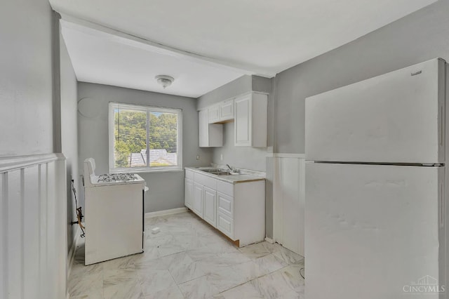 146 Glenridge Pl, Cincinnati, OH 45217 - kitchen with freestanding refrigerator, white cabinetry, gas range oven, and light marble finish flooring