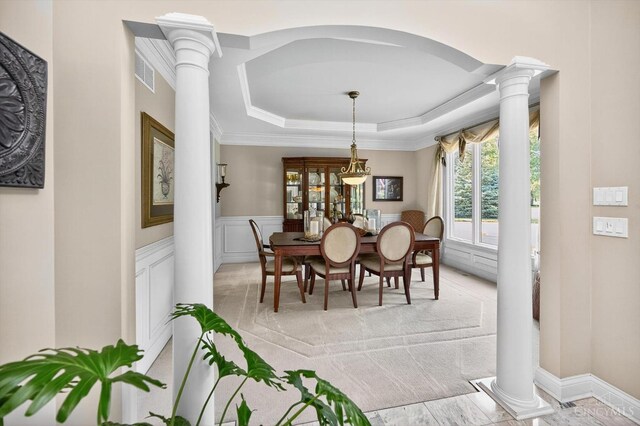 8069 Green Lake Dr, Liberty Twp, OH 45044 - dining area featuring ornate columns, a raised ceiling, ornamental molding, wainscoting, and a decorative wall