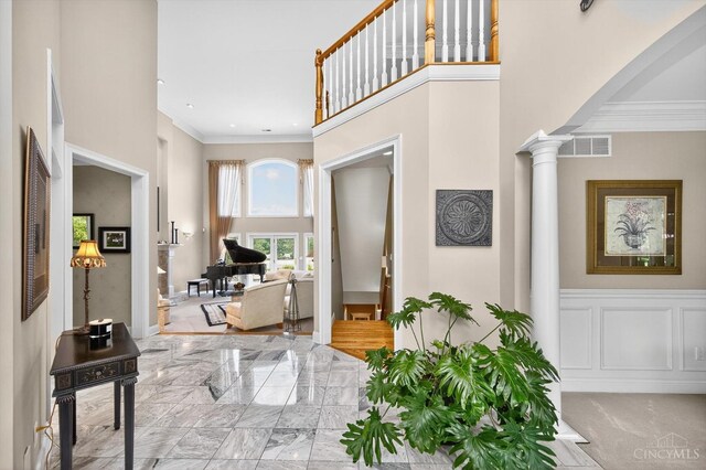 8069 Green Lake Dr, Liberty Twp, OH 45044 - entryway featuring decorative columns, ornamental molding, marble tiled floors, a high ceiling, and arched walkways