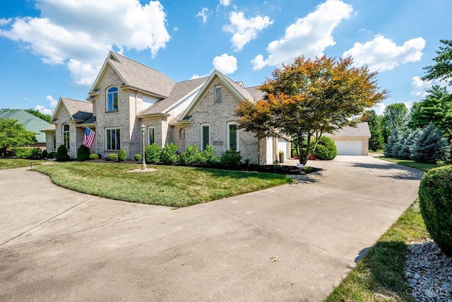 8069 Green Lake Dr, Liberty Twp, OH 45044 - french country inspired facade featuring driveway, a front lawn, brick siding, and an attached garage
