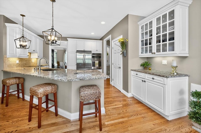 8069 Green Lake Dr, Liberty Twp, OH 45044 - kitchen featuring stainless steel appliances, a breakfast bar area, a peninsula, white cabinetry, and recessed lighting