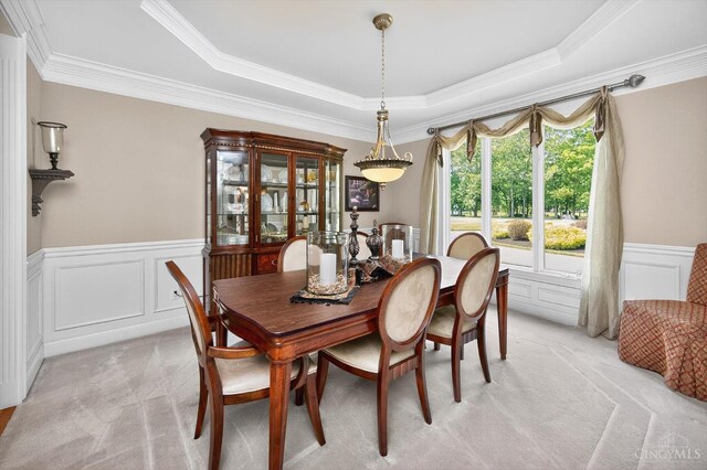 8069 Green Lake Dr, Liberty Twp, OH 45044 - dining area featuring light carpet, a raised ceiling, a decorative wall, wainscoting, and crown molding