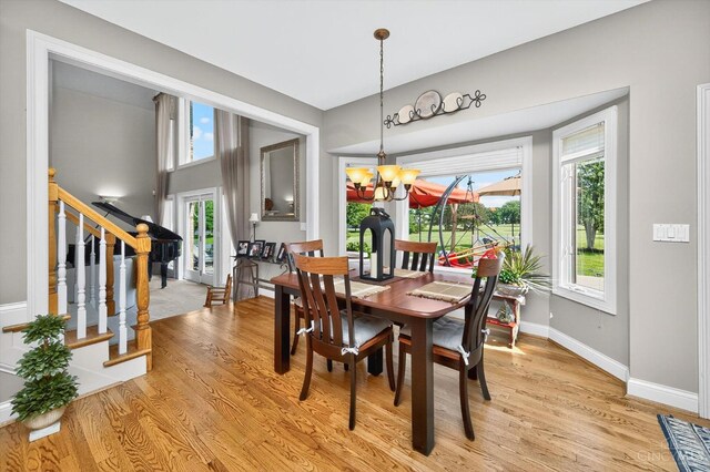 8069 Green Lake Dr, Liberty Twp, OH 45044 - dining space featuring a chandelier, light wood-style floors, and stairs