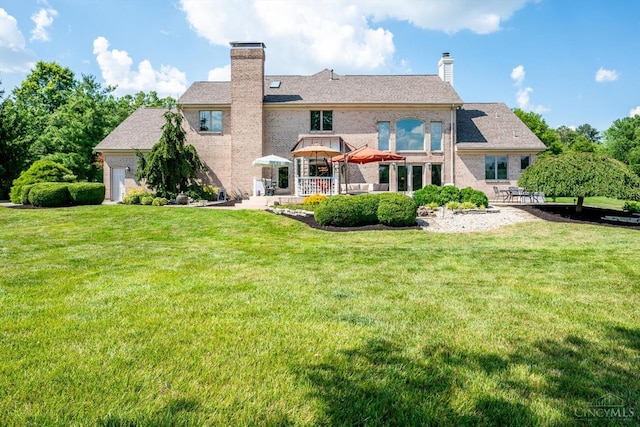 8069 Green Lake Dr, Liberty Twp, OH 45044 - rear view of property featuring a chimney, a patio area, a yard, and brick siding