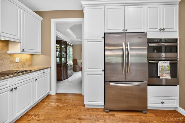 8069 Green Lake Dr, Liberty Twp, OH 45044 - kitchen featuring appliances with stainless steel finishes, light wood-style flooring, white cabinetry, decorative backsplash, and stone counters
