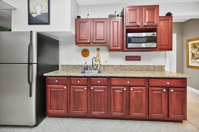 8069 Green Lake Dr, Liberty Twp, OH 45044 - kitchen with stainless steel appliances, reddish brown cabinets, and light stone countertops