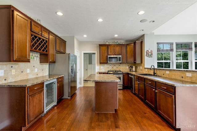 1820 Meadow Sweet Dr, Turtle Creek Twp, OH 45036 - kitchen with stainless steel appliances, wine cooler, a kitchen island, dark wood finished floors, and decorative backsplash