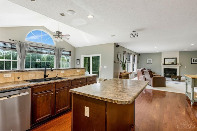 1820 Meadow Sweet Dr, Turtle Creek Twp, OH 45036 - kitchen featuring stainless steel dishwasher, a kitchen island, vaulted ceiling, a glass covered fireplace, and a ceiling fan