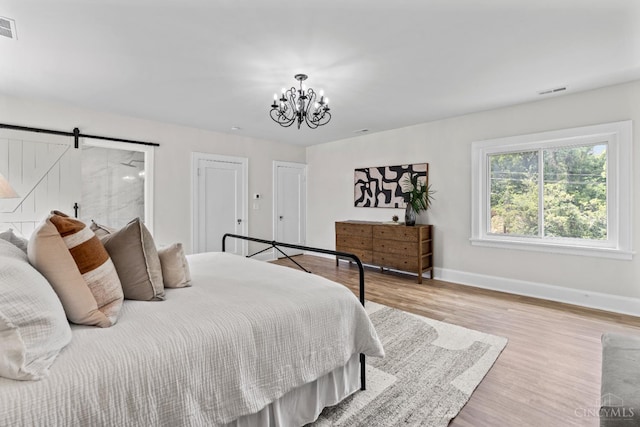 4150 Paddock Rd, Cincinnati, OH 45229 - bedroom featuring a chandelier, wood finished floors, and a barn door