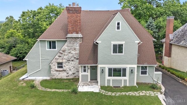 4150 Paddock Rd, Cincinnati, OH 45229 - tudor home with stucco siding, a chimney, a front lawn, and stone siding