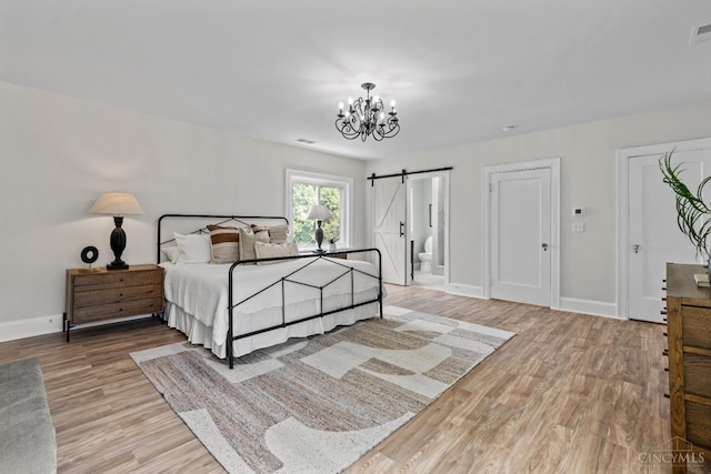 4150 Paddock Rd, Cincinnati, OH 45229 - bedroom featuring a barn door, a chandelier, and light wood-style floors