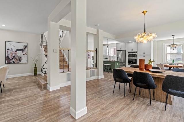 4150 Paddock Rd, Cincinnati, OH 45229 - dining area with light wood-style flooring, a chandelier, stairway, and recessed lighting
