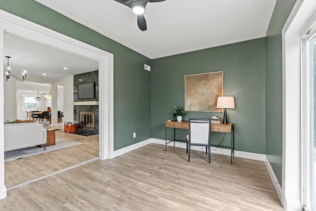 4150 Paddock Rd, Cincinnati, OH 45229 - home office with ceiling fan, a chandelier, wood finished floors, and a large fireplace
