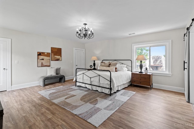 4150 Paddock Rd, Cincinnati, OH 45229 - bedroom featuring a chandelier, wood finished floors, and a barn door