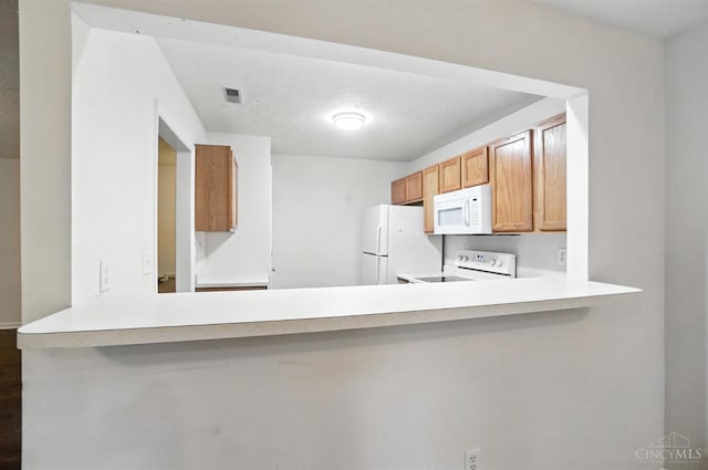 5433 Harbourwatch Unit 104, Deerfield Twp, OH 45040 - kitchen with white appliances, light countertops, a peninsula, and dark wood-style floors