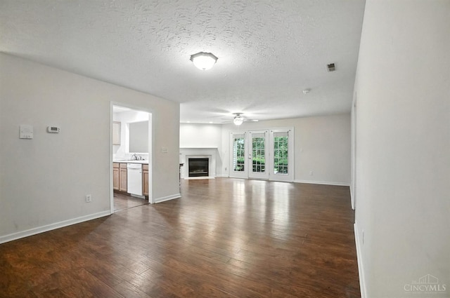 5433 Harbourwatch Unit 104, Deerfield Twp, OH 45040 - unfurnished living room featuring dark wood-style flooring, a textured ceiling, a fireplace, and ceiling fan