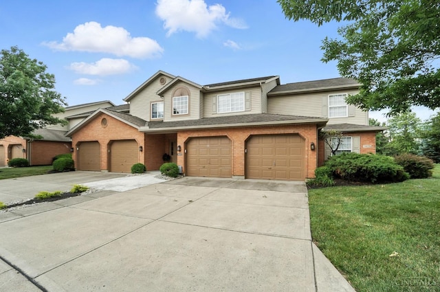 5433 Harbourwatch Unit 104, Deerfield Twp, OH 45040 - view of front of home with concrete driveway, brick siding, a front yard, and a garage