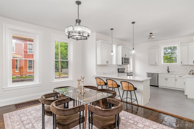 1419 Chase Ave, Cincinnati, OH 45223 - dining area featuring plenty of natural light, a chandelier, and dark wood finished floors