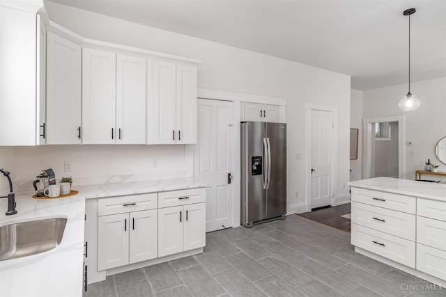 1419 Chase Ave, Cincinnati, OH 45223 - kitchen featuring stainless steel fridge, white cabinetry, and hanging light fixtures