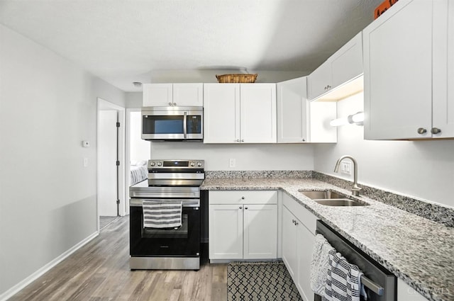 7234 Creekview Dr Unit 1, Colerain Twp, OH 45247 - kitchen featuring appliances with stainless steel finishes, light wood finished floors, white cabinets, and light stone countertops