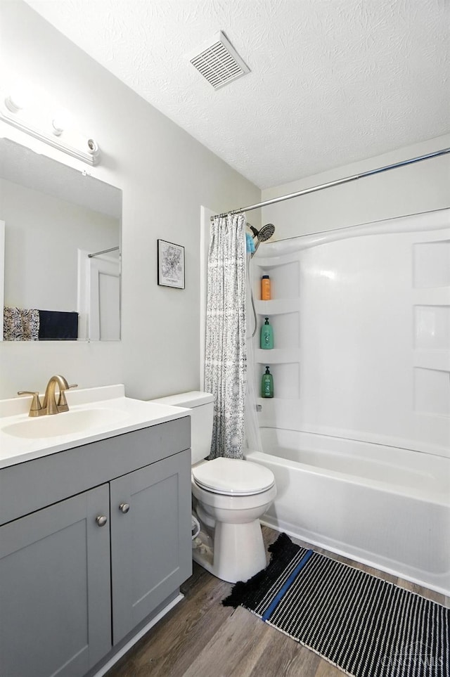 7234 Creekview Dr Unit 1, Colerain Twp, OH 45247 - bathroom featuring vanity, wood finished floors, shower / tub combo, and a textured ceiling