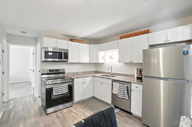 7234 Creekview Dr Unit 1, Colerain Twp, OH 45247 - kitchen with stainless steel appliances, light wood-style flooring, white cabinetry, and light stone counters